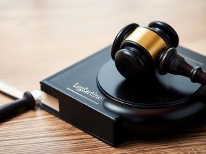 Ciocan de judecător pe o carte de lege.