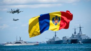 Steagul României flutură lângă avioane și nave militare.